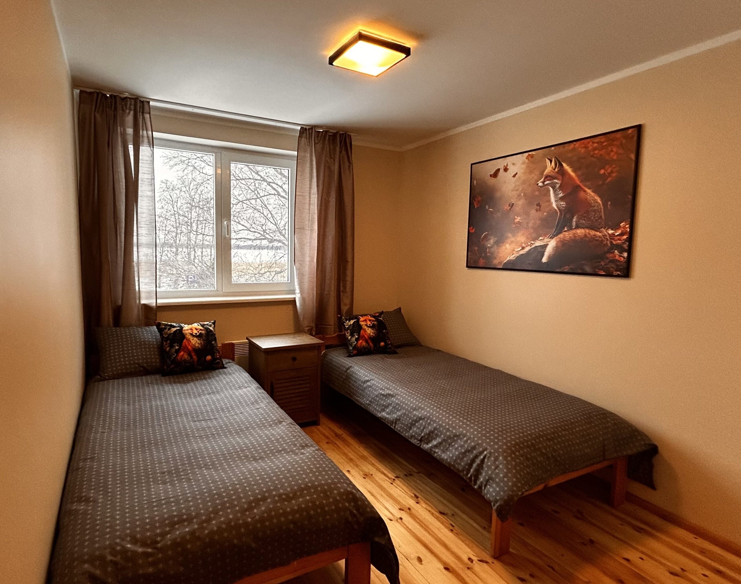 Rebaseteemaline majutus Saaremaal – tuba Rebane Suurlahe Guesthouse'is koos kunstipärase rebasemaaliga.