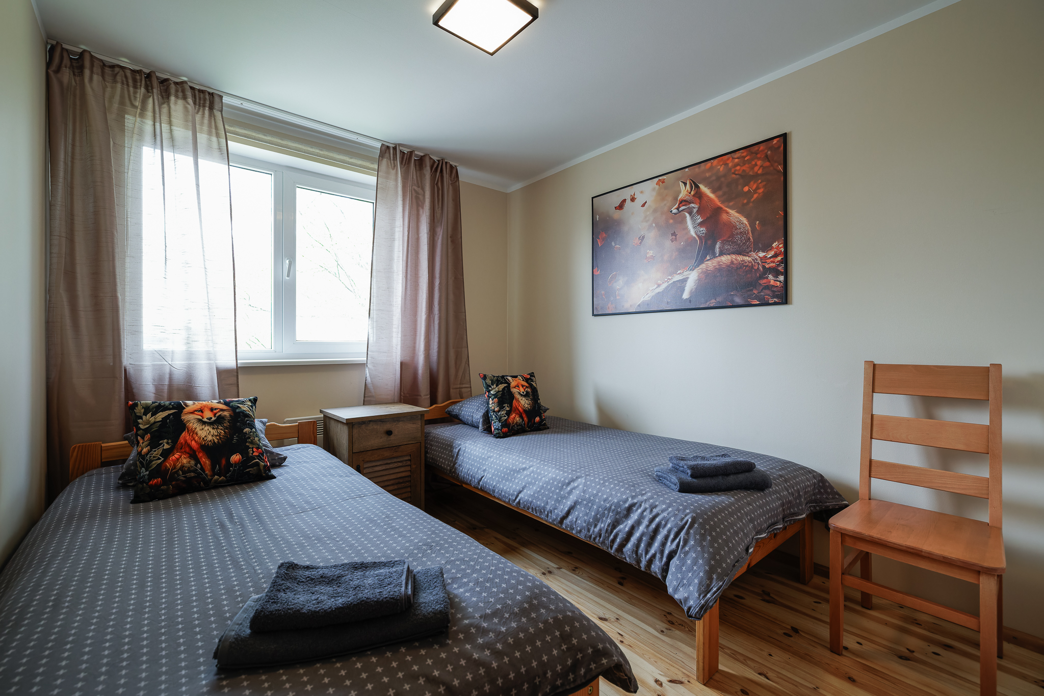 REBANE toa garderoobinurk Suurlahe Guesthouse majutuses puidust riidekapi, väikese laua, valge ukse ja puidust põrandaga.