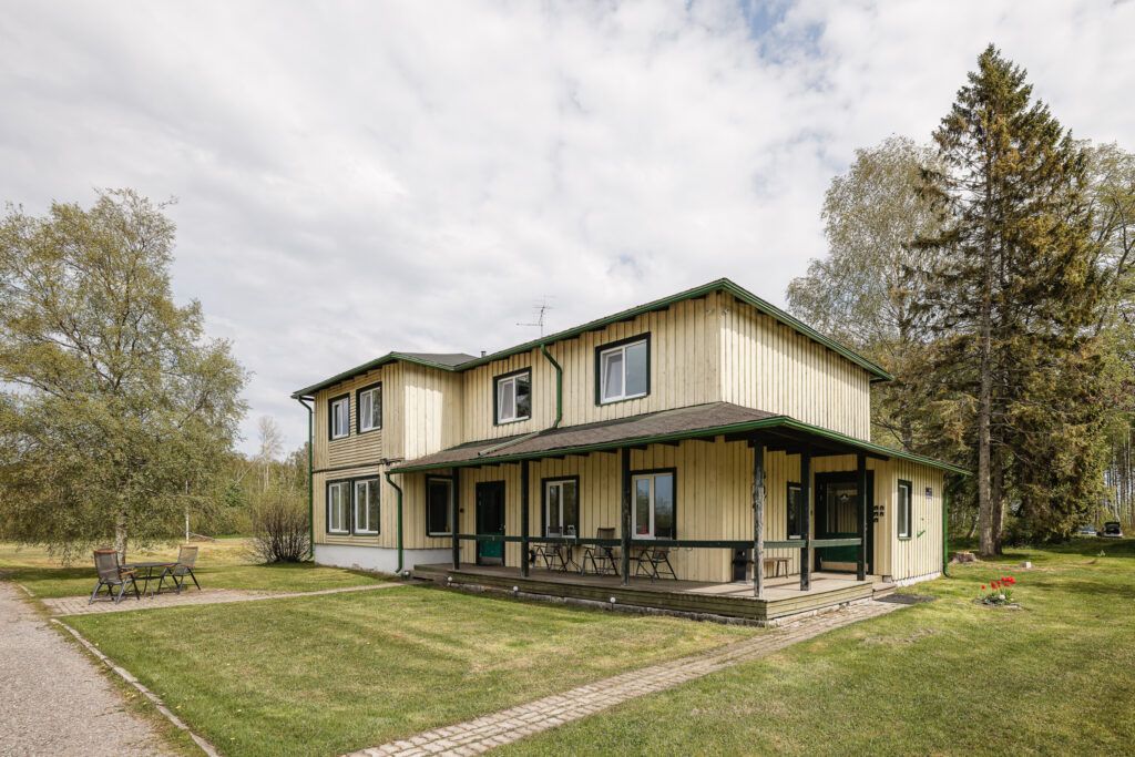 Suurlahe Guesthouse välisvaade rohelise hoovi, puude, terrassiistumise ja rahuliku maamajutuse õhkkonnaga.